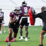 Veteran Coaching Program participant helps with drills during football practice.