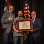 Dr. Marc Goodrich receiving an award being presented by the Dean de Miranda.