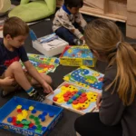 Teacher interacting with kids and playing with learning toys.